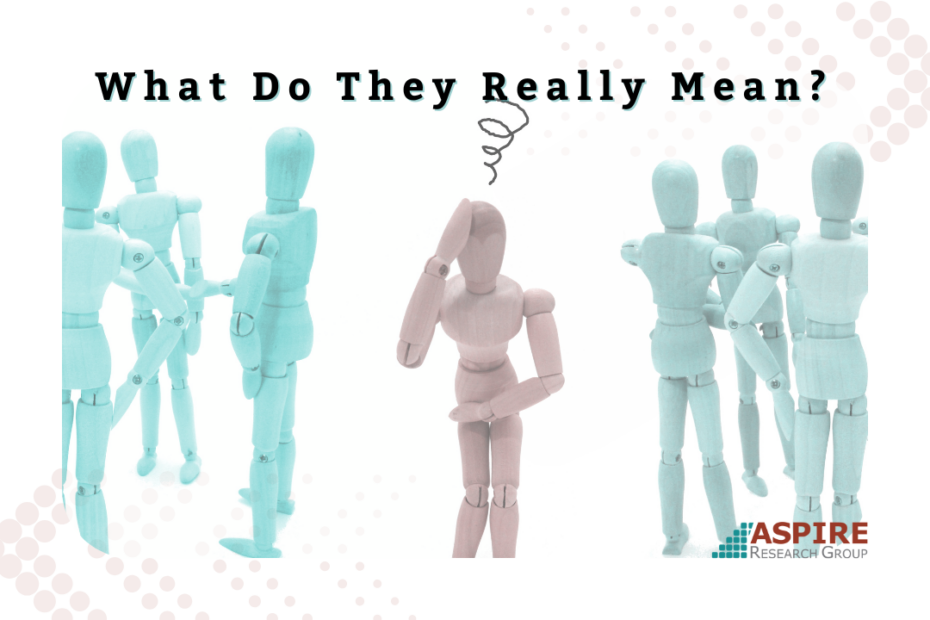 Illustration showing groups of light blue wooden mannequin figures standing on either side of a single pink mannequin figure in the center. The central figure appears confused, with a scribbled thought symbol overhead. The image includes the headline “What Do They Really Mean?” and represents communication misunderstandings between teams. Aspire Research Group logo appears in the bottom right corner.